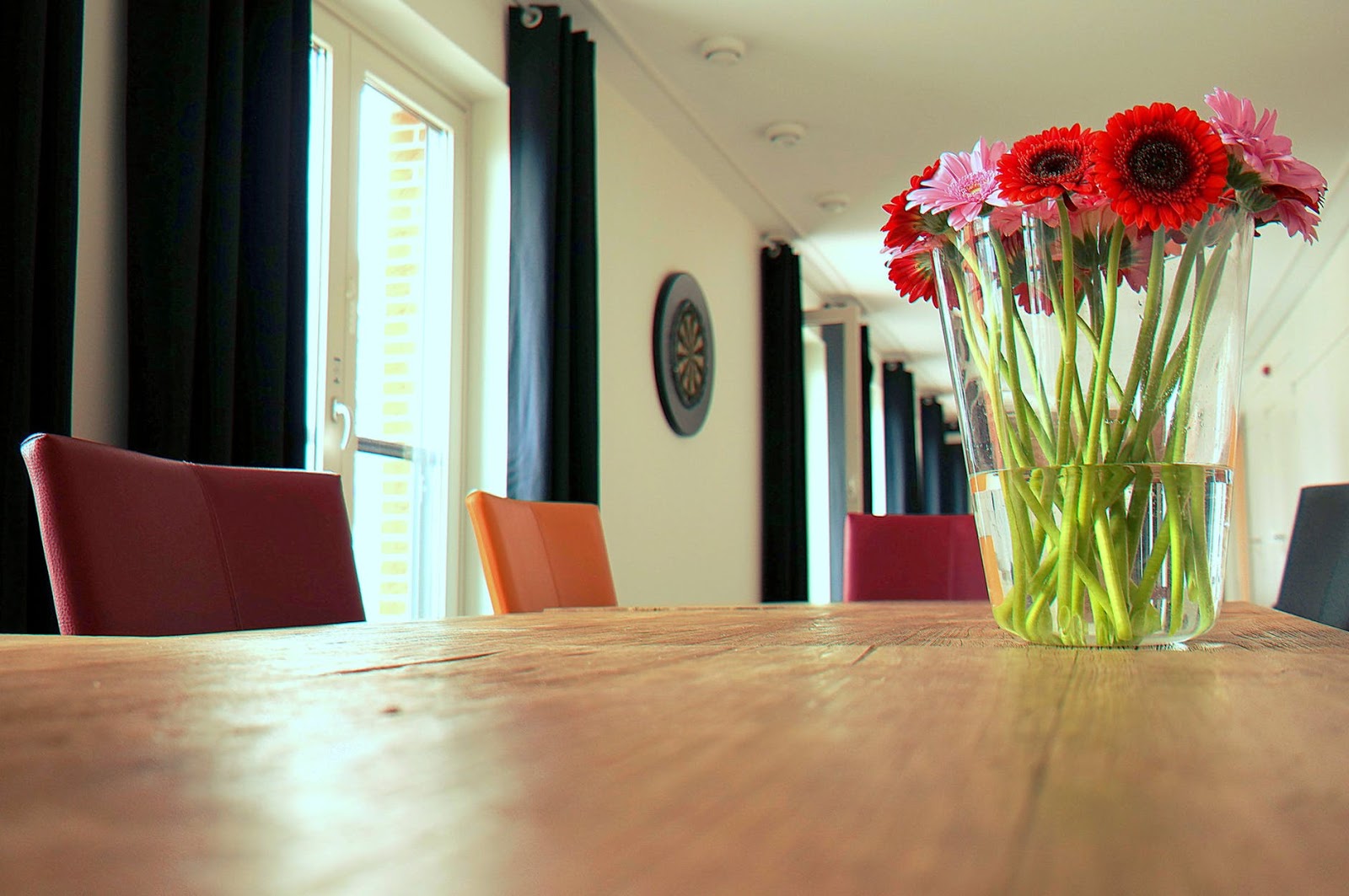 table with chairs and a vase of flowers